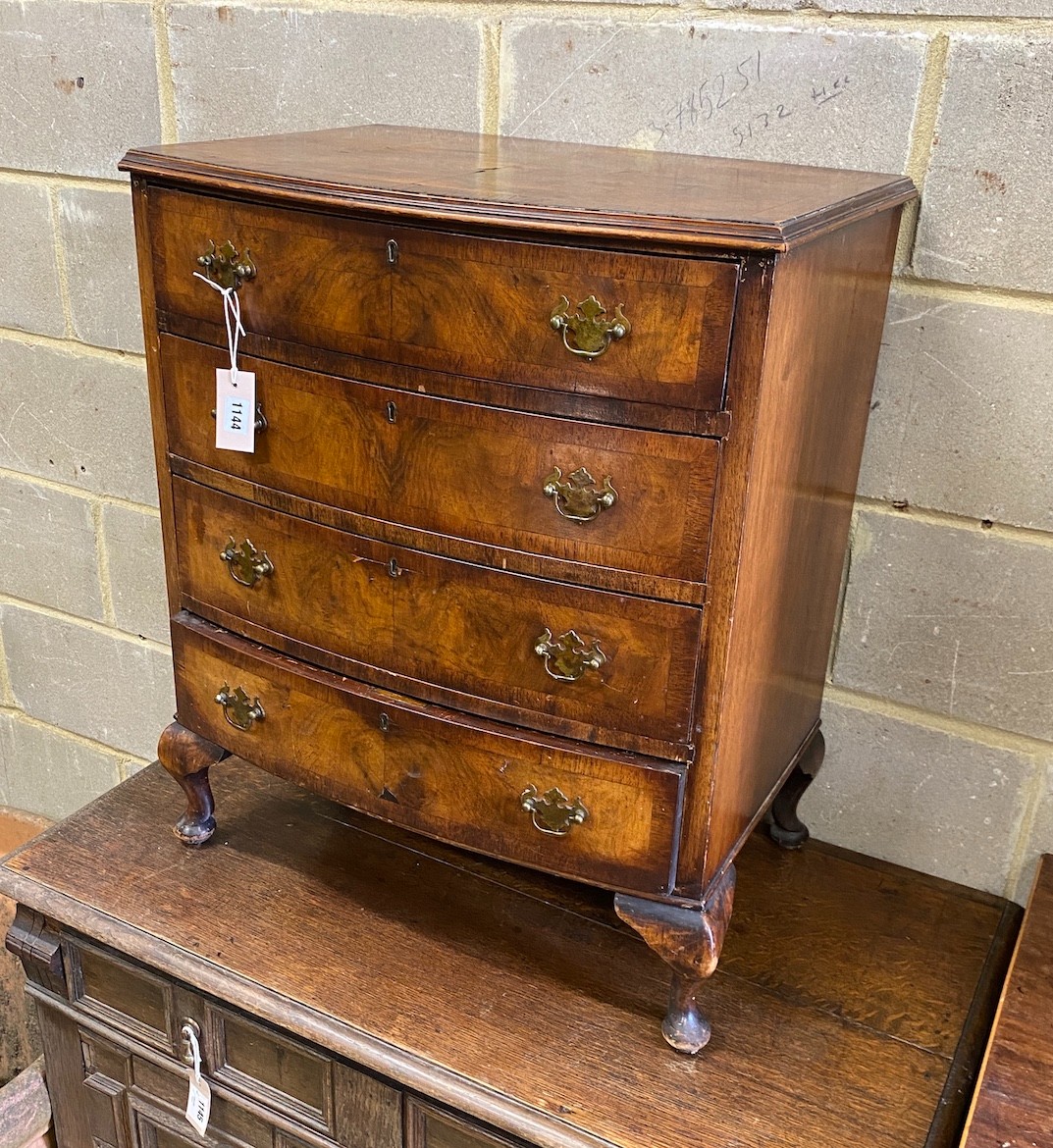 A small Queen Anne revival walnut bow front chest of four drawers, width 62cm, depth 43cm, height 74cm